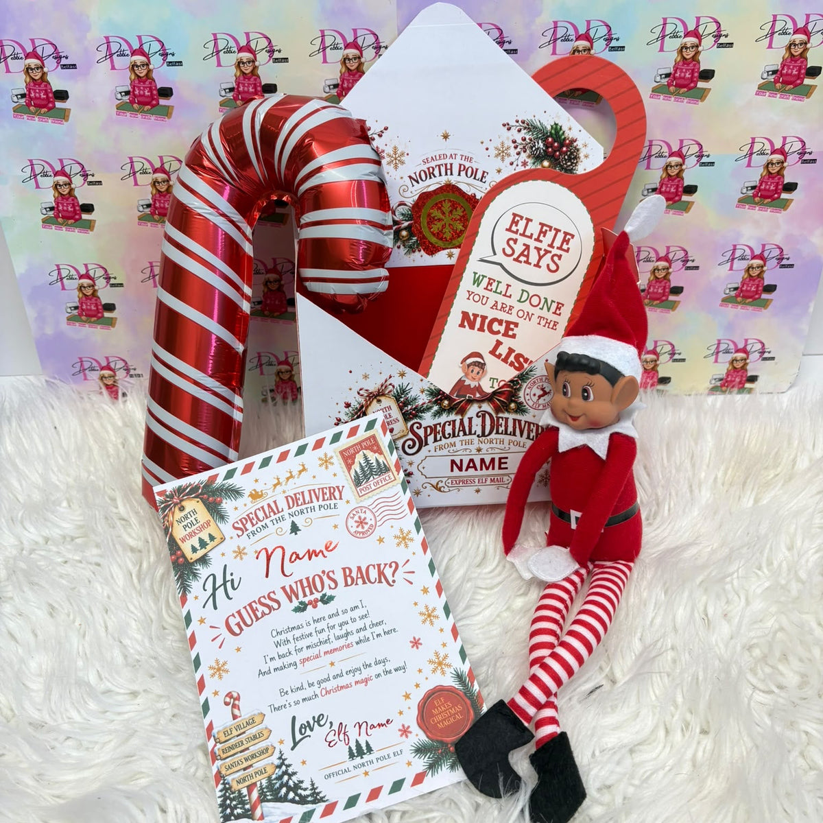 a christmas card and a toy elf sitting next to a candy cane
